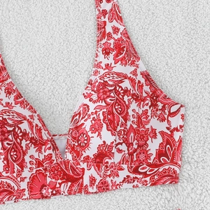 Close-up of red paisley print and fine stitching on a white halter bikini top detail