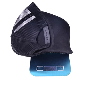 Casquette de baseball en maille noire avec perles strass pesant 128g sur une balance