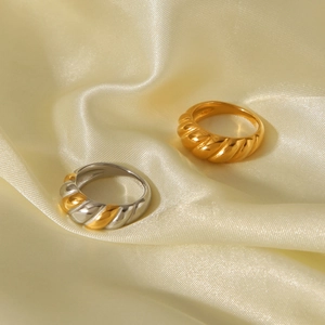 Detail of gold and silver croissant rings on silk background with polished finish