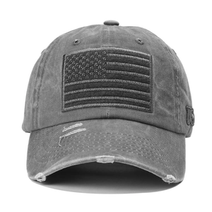 Close-up of distressed cotton baseball cap with USA flag embroidery and torn brim details