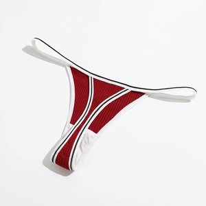 Detail of red ribbed cotton thong with black and white striped elastic waistband
