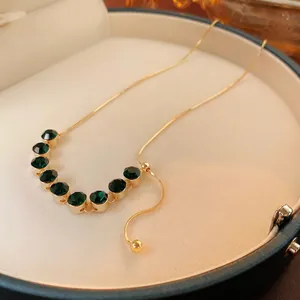 Collana placcata oro 18 carati con zirconi verde smeraldo su display di lusso