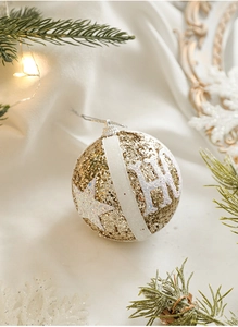 Detail of champagne gold Christmas ball with HO letters and sparkling glitter stars