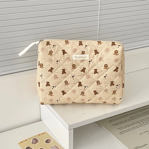 Dettaglio della trousse trapuntata beige con graziosi motivi di orsetti e coniglietti