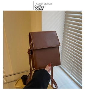 Close-up of minimalist coffee brown crossbody bag with fine texture and adjustable strap