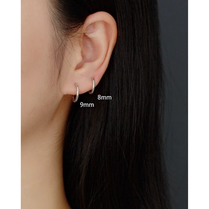 Detail of 8mm and 9mm S925 silver hoop earrings on ear with visible S925 hallmark