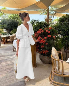 Close-up of white two-piece set featuring V-neck ruffle top and flowing maxi skirt detail