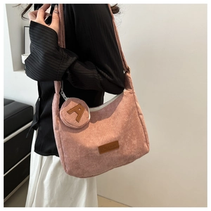 Detailed view of pink corduroy tote bag with fashion patch and letter A charm accessory