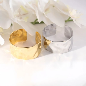 Irregular textured wide open bracelets in gold and silver finish with white floral accent