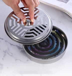Detail showing hand lifting a hollow stainless steel lid from a round silver mosquito coil box