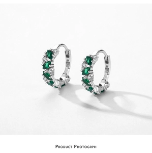 Gros plan du poinçon S925 sur boucles d'oreilles couronne avec pierres marquises