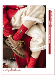 Détail de chaussettes en coton rouge avec une broderie de sapin de Noël sur le côté