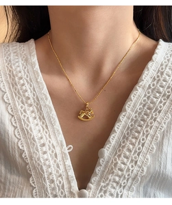 Detail view of a 18k gold plated rocking horse pendant on a delicate necklace for women
