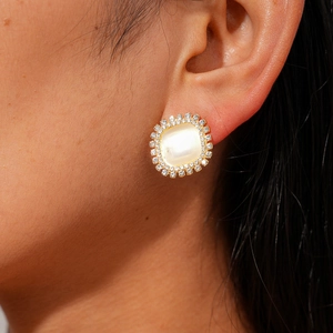 Close-up of vintage square stud earring with opal stone and diamond halo on ear