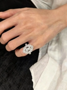 Macro detail of a marquise cut zircon ring with intricate halo setting on a finger