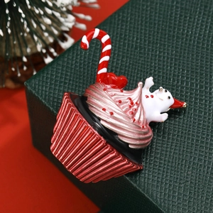 Christmas cupcake brooch with snowman and candy cane on a green gift box background