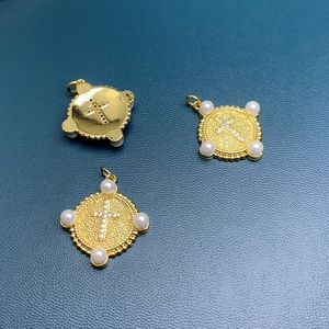Golden cross pendant with white pearls on dark blue surface, front and back view details
