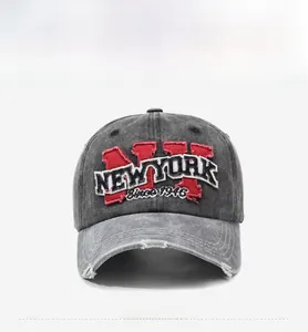 Detailed view of grey washed denim baseball cap with NY embroidery and distressed brim