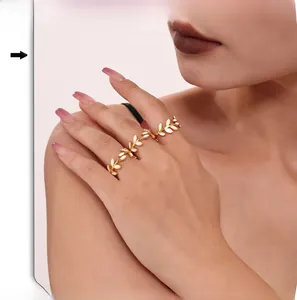 Detailed view of leaves pattern rings in 18k gold plating on model's fingers