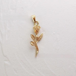 Detail shot of a blooming rose pendant in 18K gold plated stainless steel with leaf textures