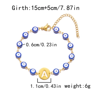 Detail view of gold Evil Eye bracelet with blue beads and engraved letter A pendant