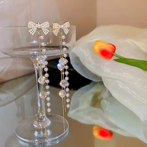Détail de boucles d'oreilles pendantes avec perles et cristaux sur un verre