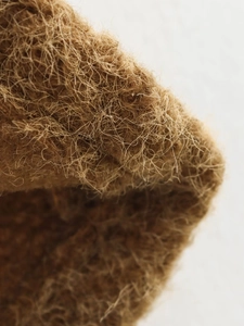 Detailed texture of brown mohair vest fabric showing high-quality cozy fiber material