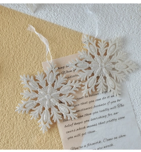 Close-up of sparkling white snowflake ornaments with silver glitter and tulle ribbons