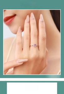 Close-up of minimalist silver ring with round pink tourmaline gemstone on a model's finger
