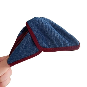 Denim fabric triangle hair claw clip with red piping trim on a clean background