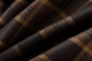 Macro shot of brown plaid fabric showing detailed twill weave and soft texture on mini skirt
