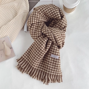 Detailed view of brown and white houndstooth wool blend scarf with fringe tassels