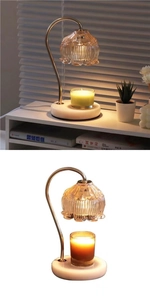 Detail of candle warmer with amber glass shade, gold metal arm and marble base