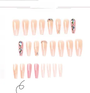 Détail de faux ongles ballerine dégradé rose avec strass luxueux et paillettes