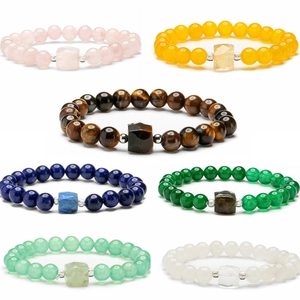 Set of seven natural stone bead bracelets featuring tiger eye, lapis and quartz on white