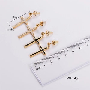 Detail view of gold cross tassel earrings with sparkling crystals and size measurements