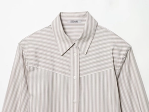 Detail der grau gestreiften Popeline-Bluse mit Schulterpolstern und dezentem Etikett