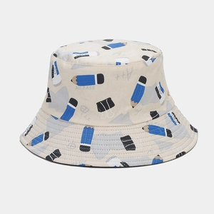 Detail of beige cotton bucket hat featuring blue pencil and stationery print design