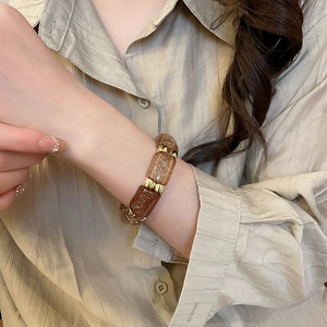 Detailed shot of amber brown acrylic beads with gold spacers on a stylish stretch bracelet