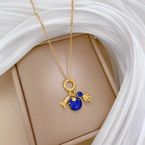 Detail view of gold space necklace with blue planet, astronaut and rocket charms