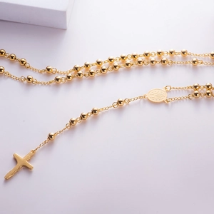 Detailed close-up of a gold-plated stainless steel rosary necklace with cross pendant