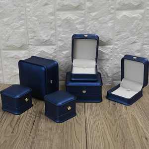 Deep blue PU leather jewelry box set with crown detail on wooden surface