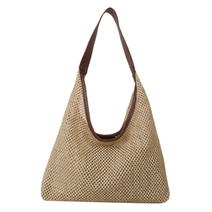 Fashionable beige woven straw shoulder bag with brown leather handles for summer beach travel