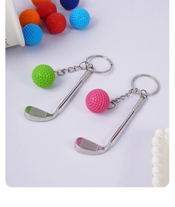 Close-up of mini metal golf club and colorful textured ball pendant keychains