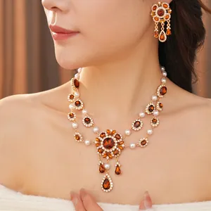 Vintage gold jewelry set with water drop pearls and amber crystals on elegant model