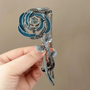 Détail d'une pince à cheveux rose en émail bleu avec strass sur monture en alliage argent