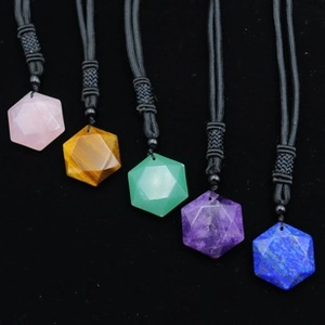 Close-up of five hexagonal natural stone pendants with black braided cords in various colors