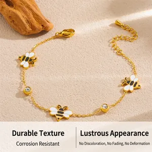 Macro view of gold-plated bee charm bracelet with enamel finish and sparkling zircons