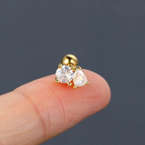 Detail of gold stud earring featuring round and teardrop zircons with screw-back ball