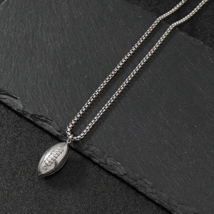 Retro stainless steel American football pendant necklace on dark slate stone background